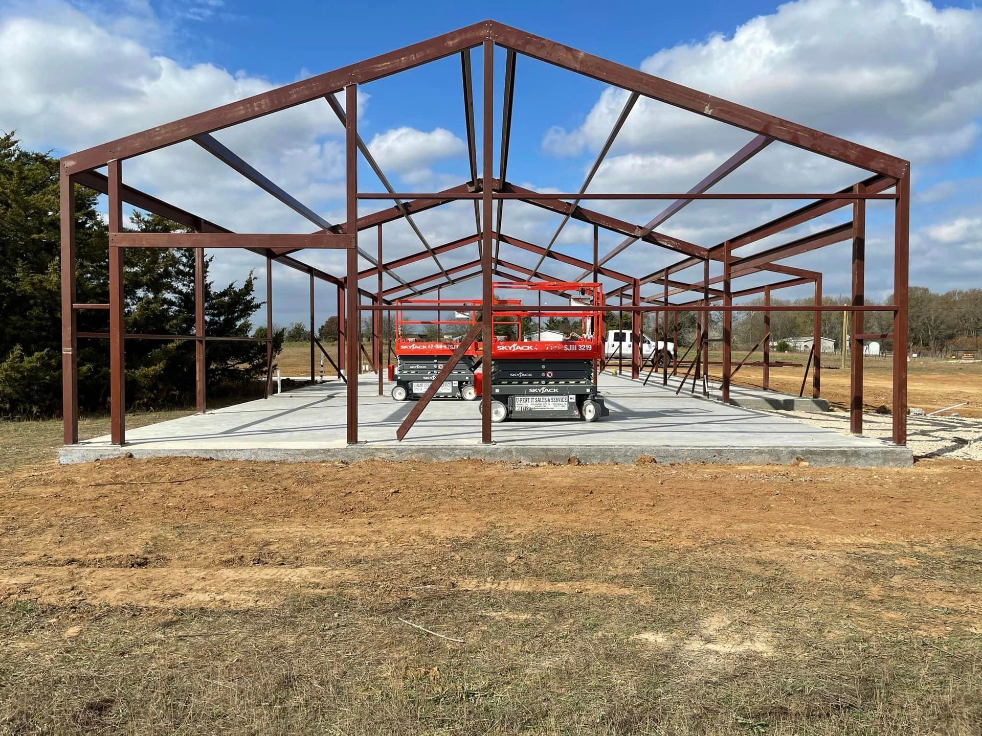 A large metal structure is being built in a field.