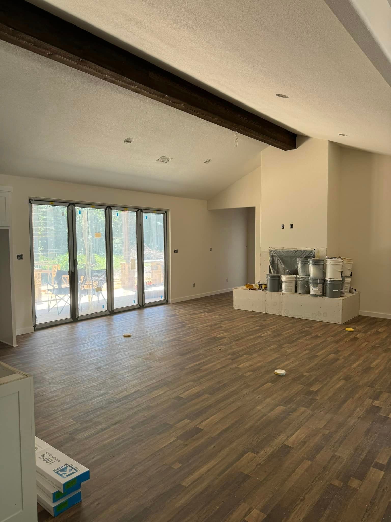 A large empty room with hardwood floors and lots of windows.