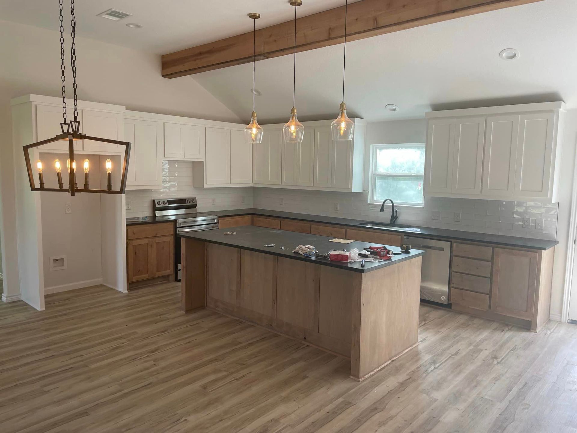 A kitchen with a large island and a chandelier hanging from the ceiling.