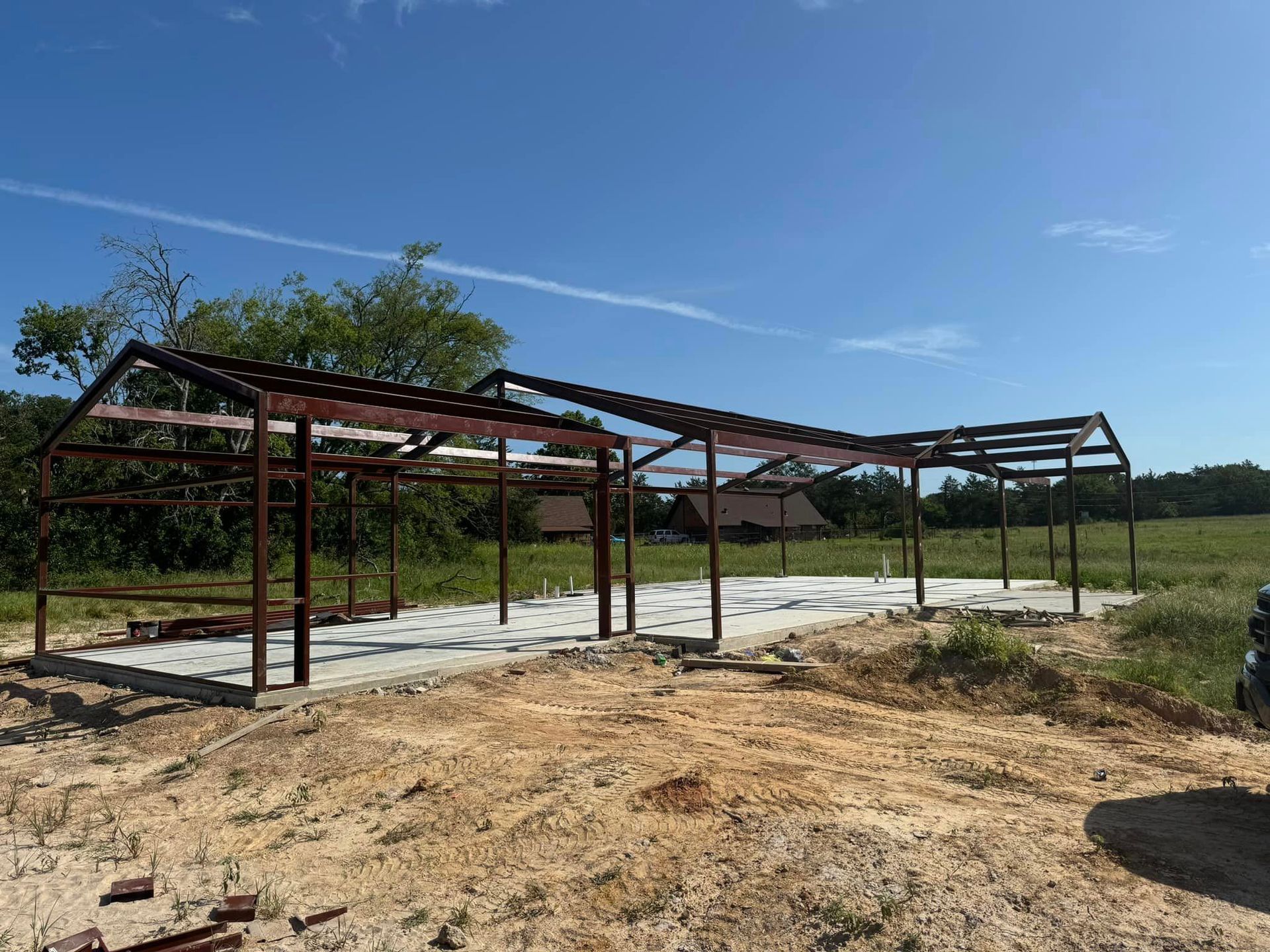 A large metal structure is being built in a field.