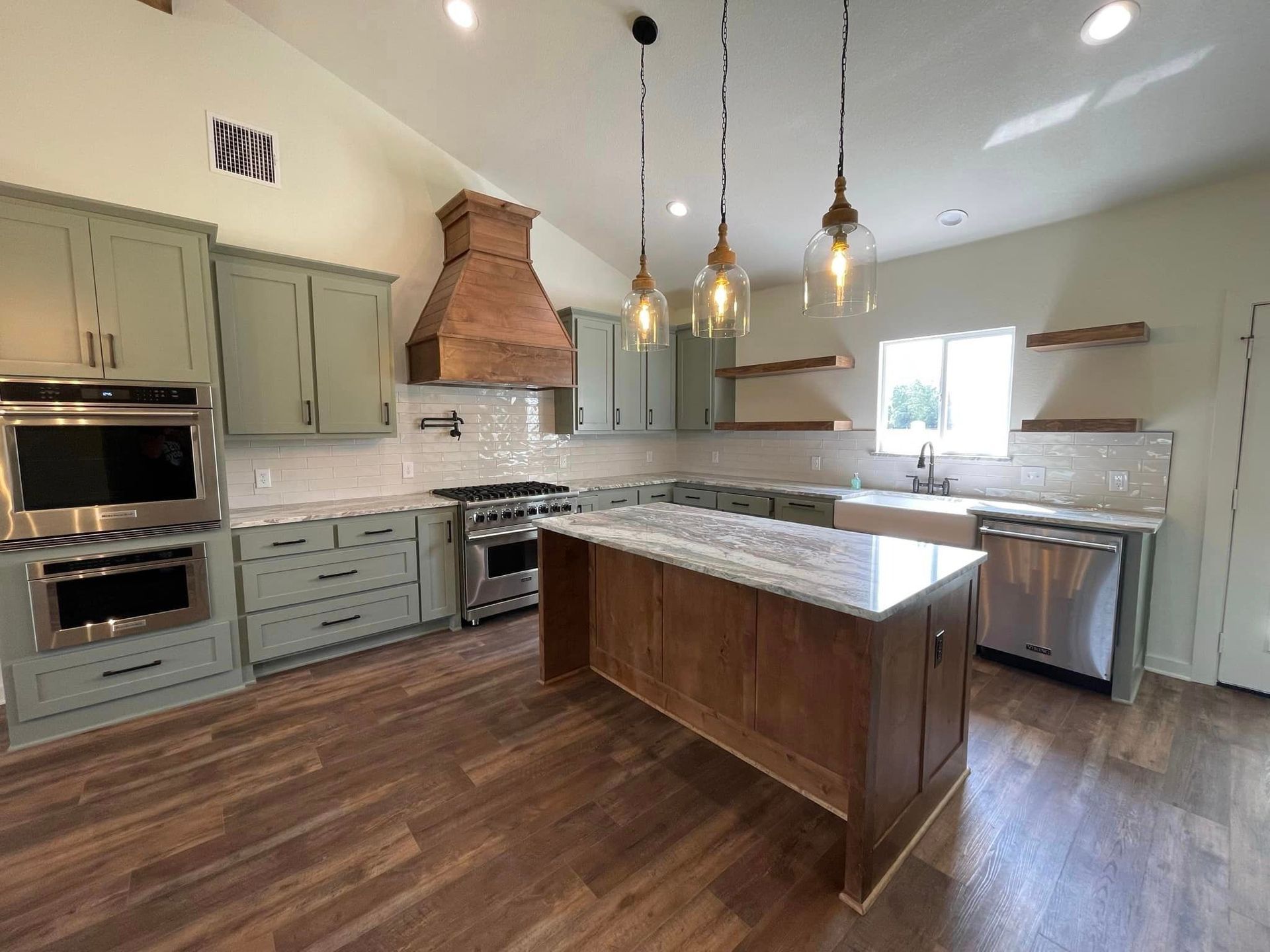 A kitchen with stainless steel appliances and a large island.