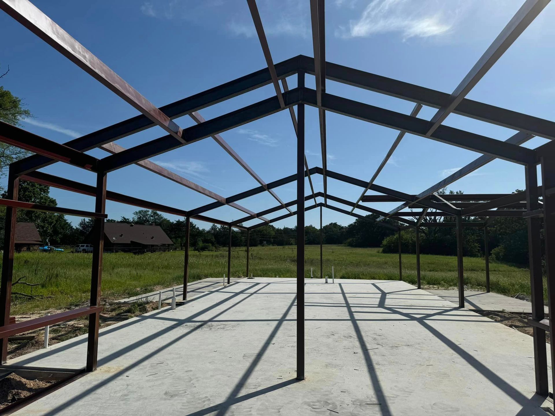 A large metal structure is being built in a field