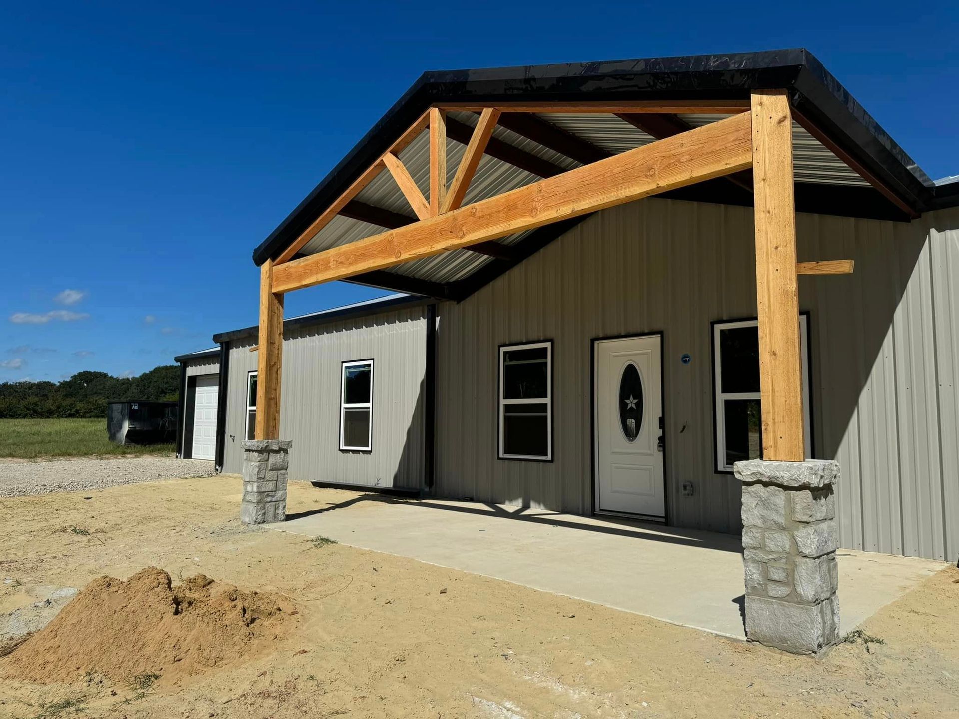 A metal building with a wooden roof and a porch