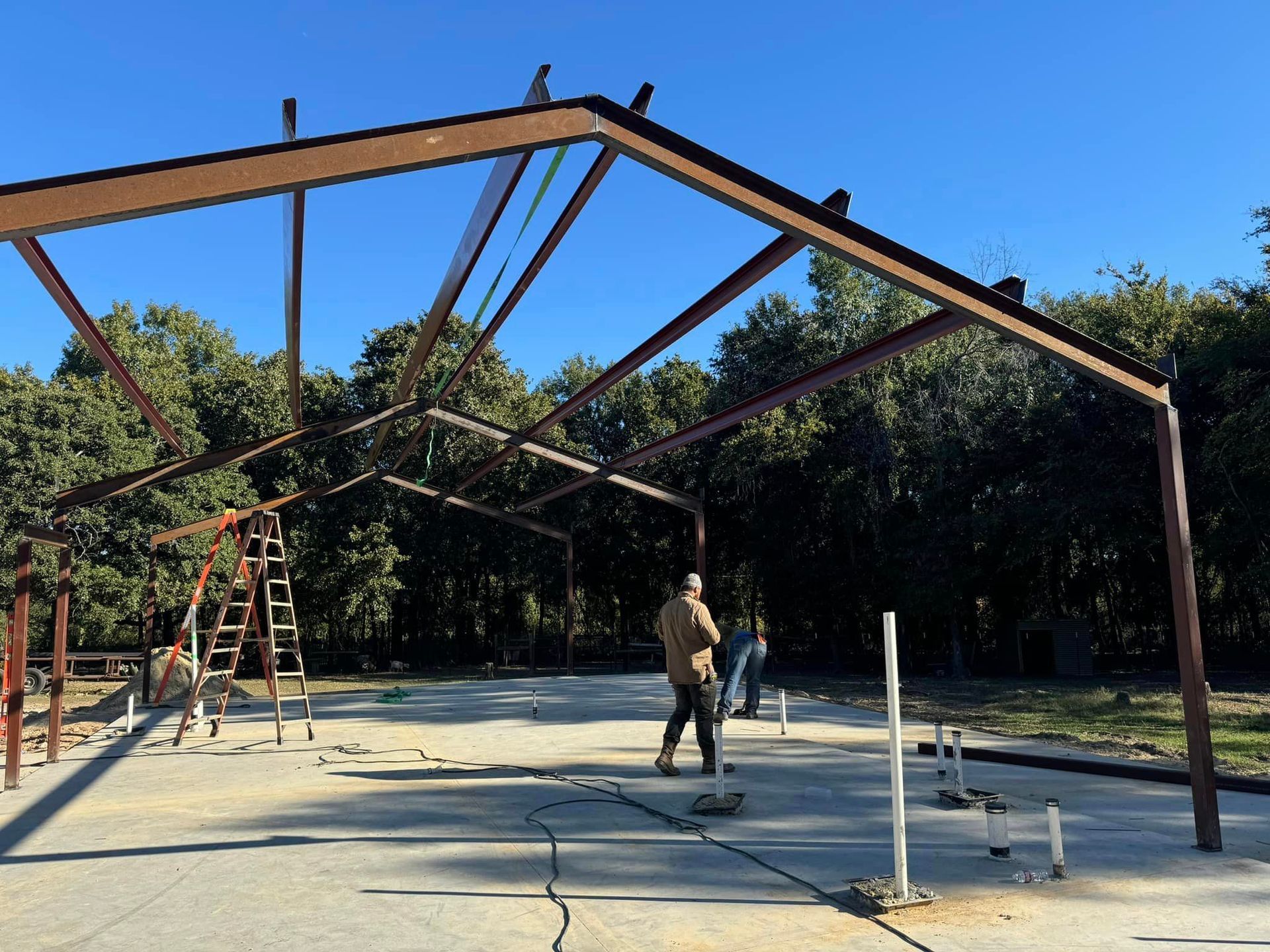 A man is standing in front of a large metal structure