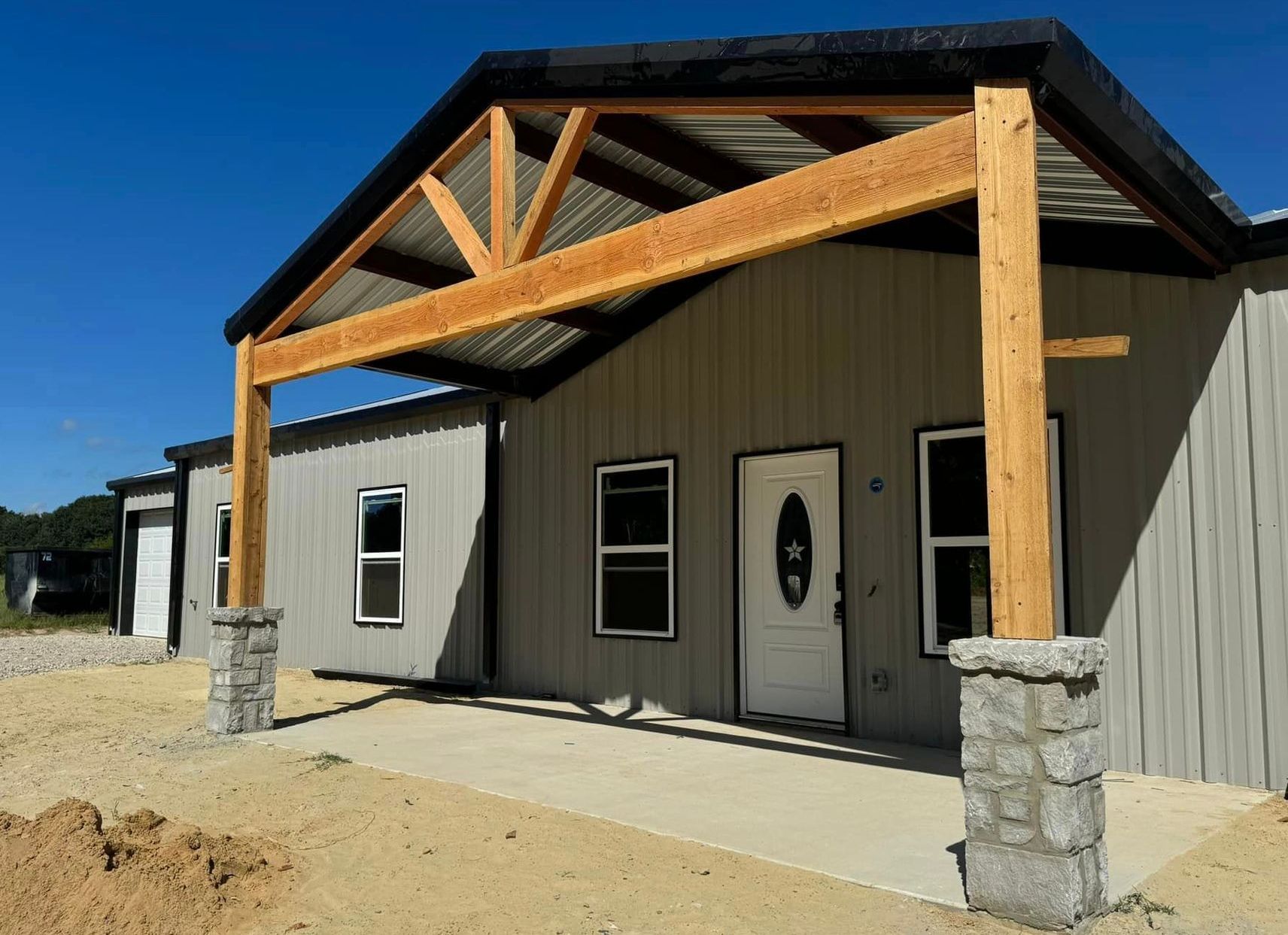 A metal building with a wooden roof and a porch