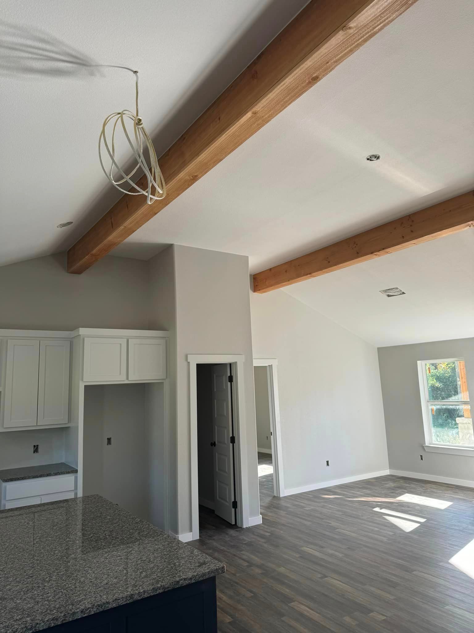 A large empty room with wooden beams hanging from the ceiling.