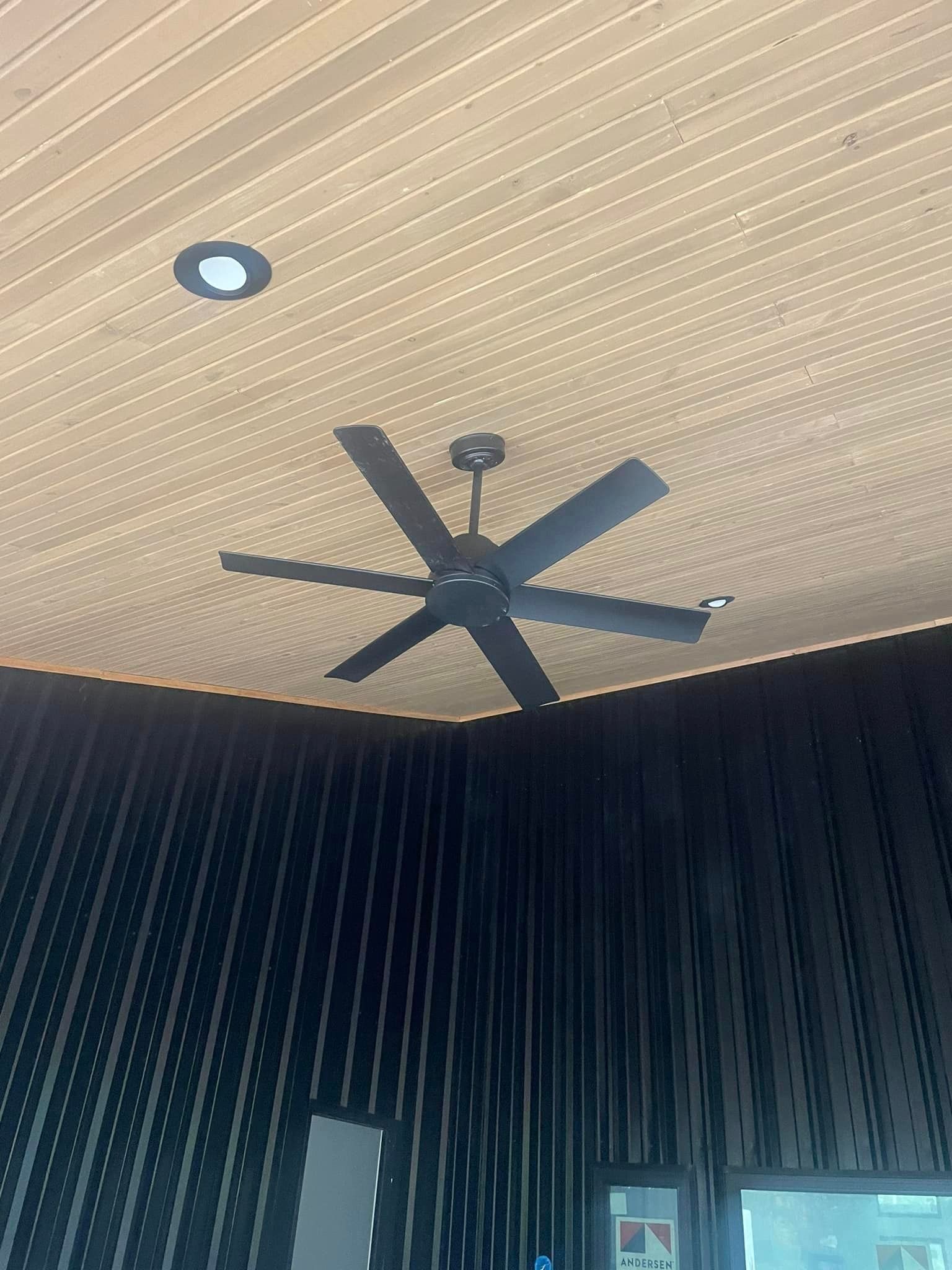 A ceiling fan is hanging from the ceiling of a room.