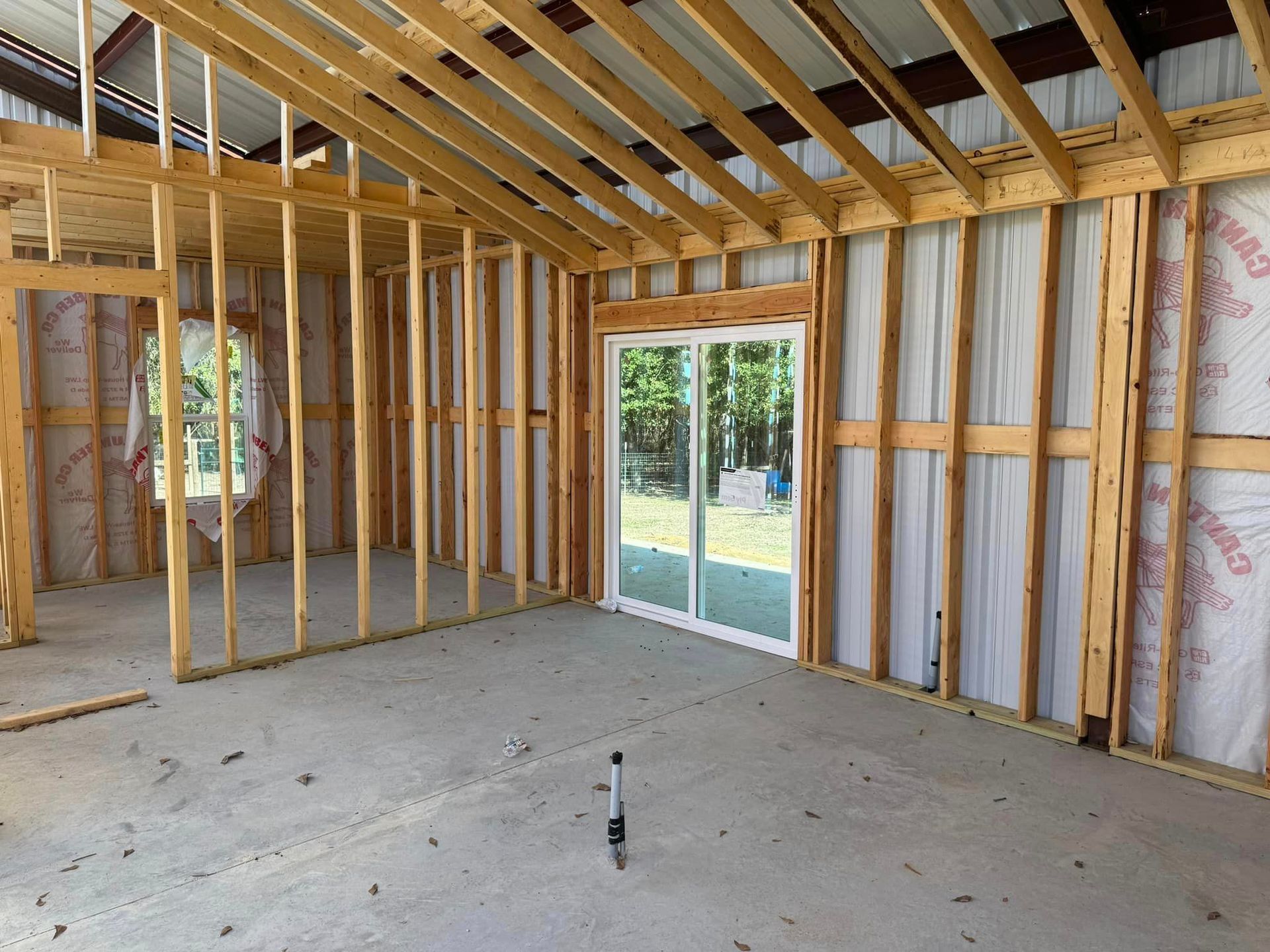 A room in a house under construction with a sliding glass door.