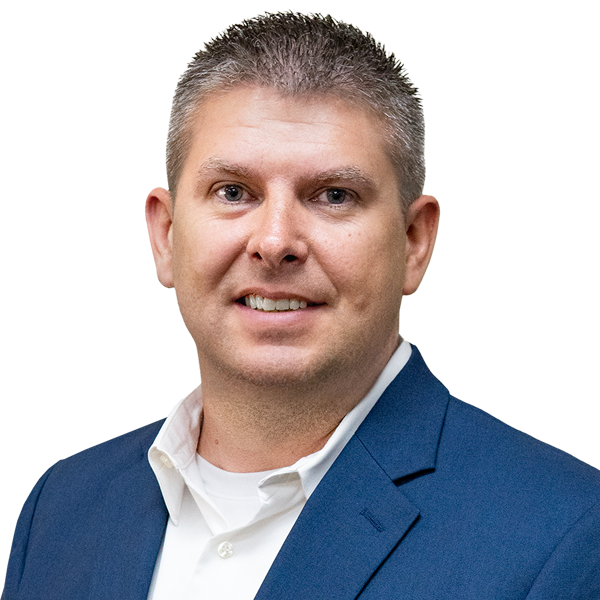A man in a blue suit and white shirt smiles for the camera