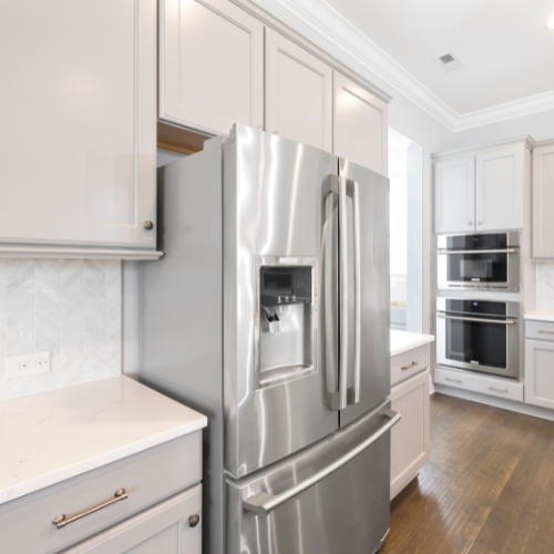 A kitchen with stainless steel appliances and white cabinets