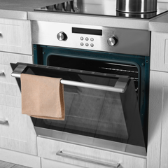 A stainless steel oven with the door open and a towel hanging from it.