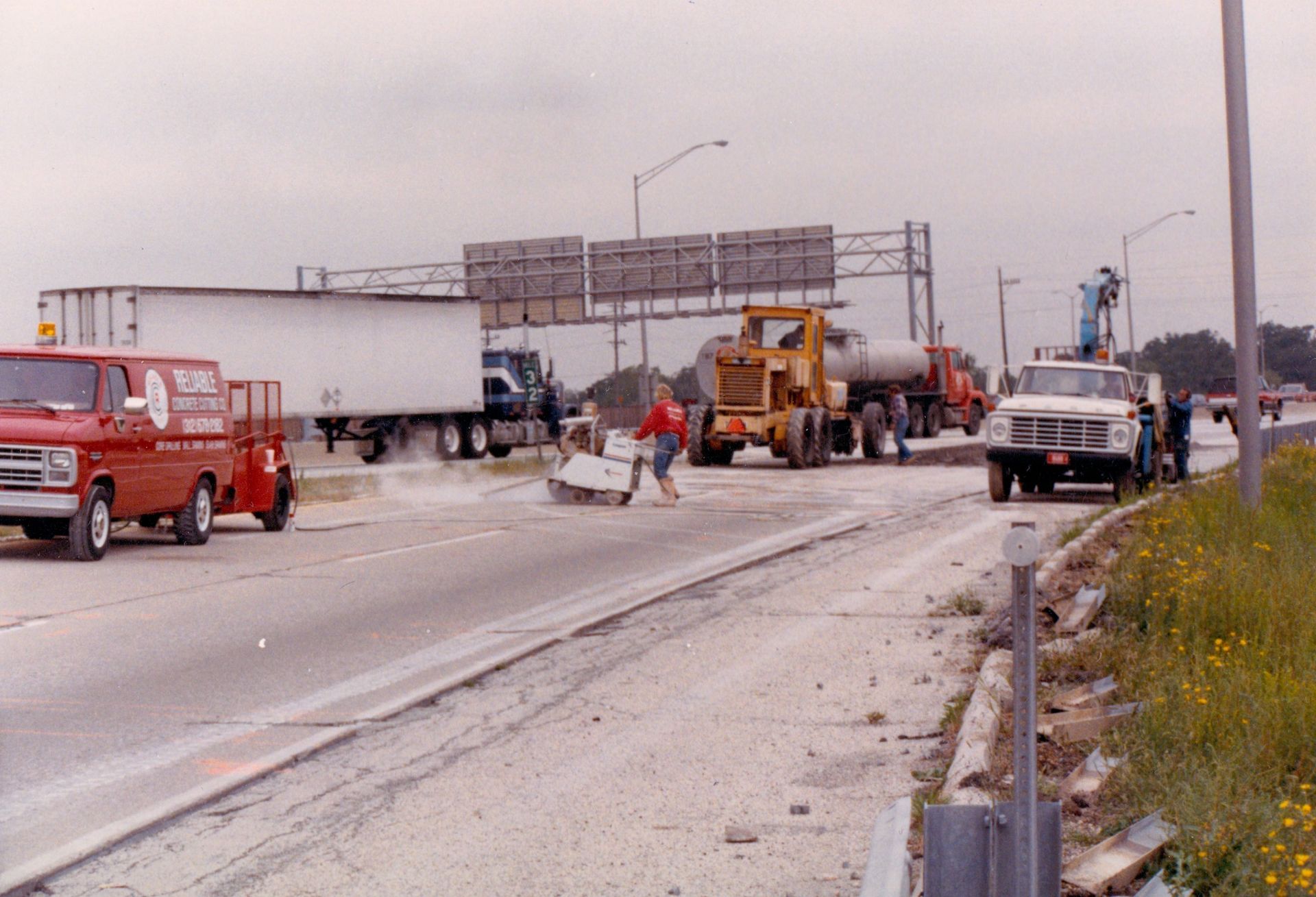 Several trucks are parked on the side of a highway