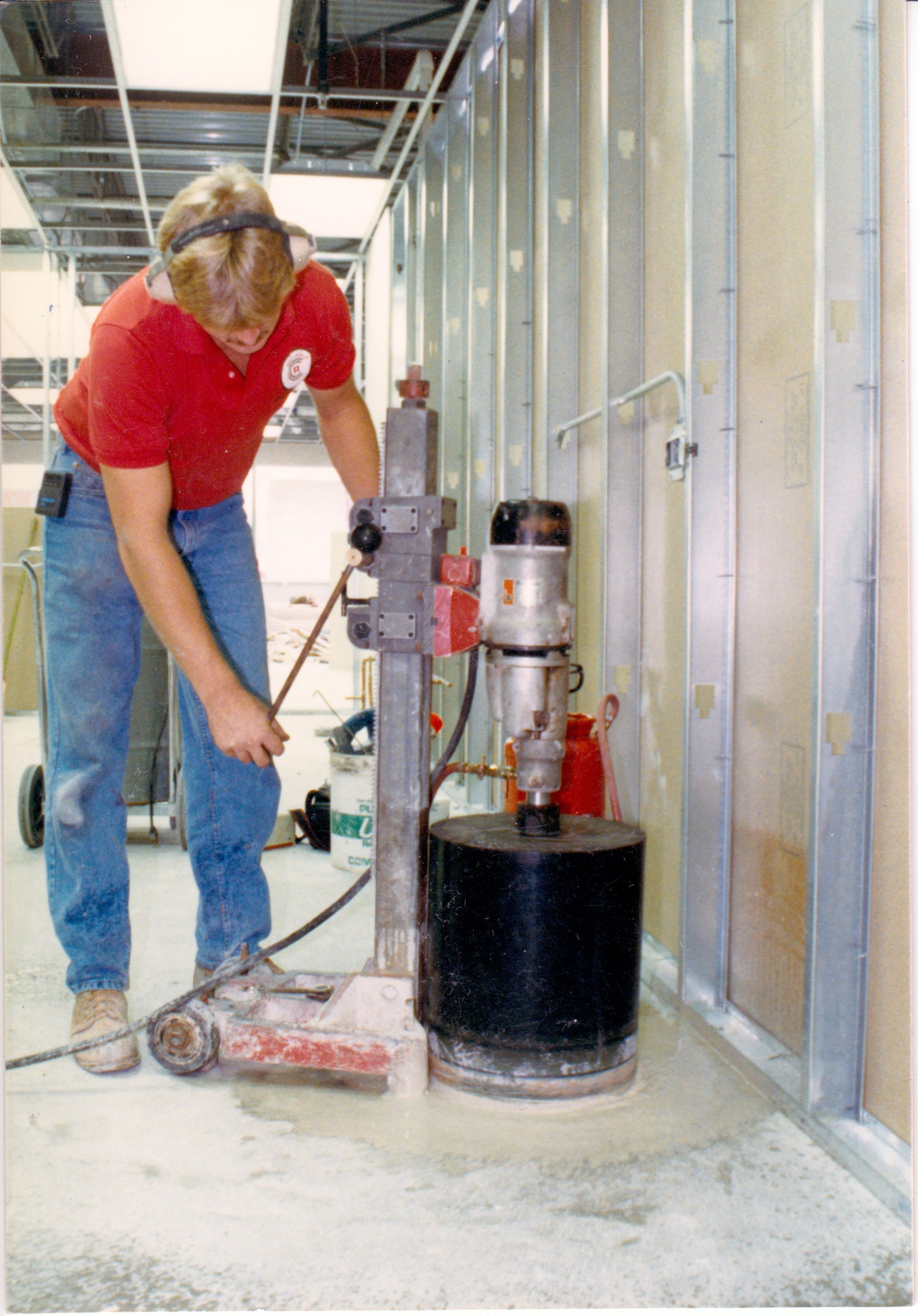A man in a red shirt is working on a machine