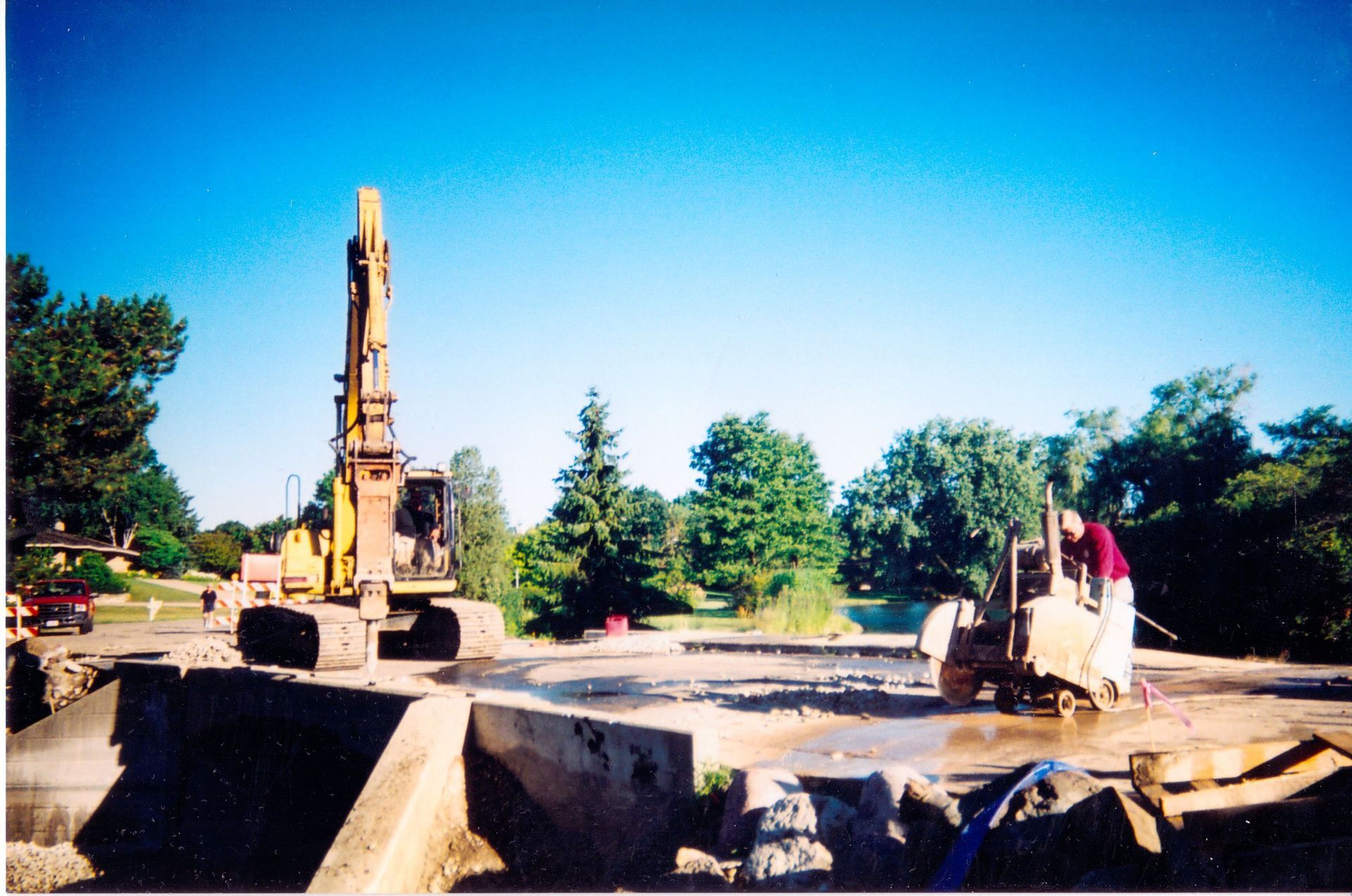 A large yellow excavator is in the middle of a construction site