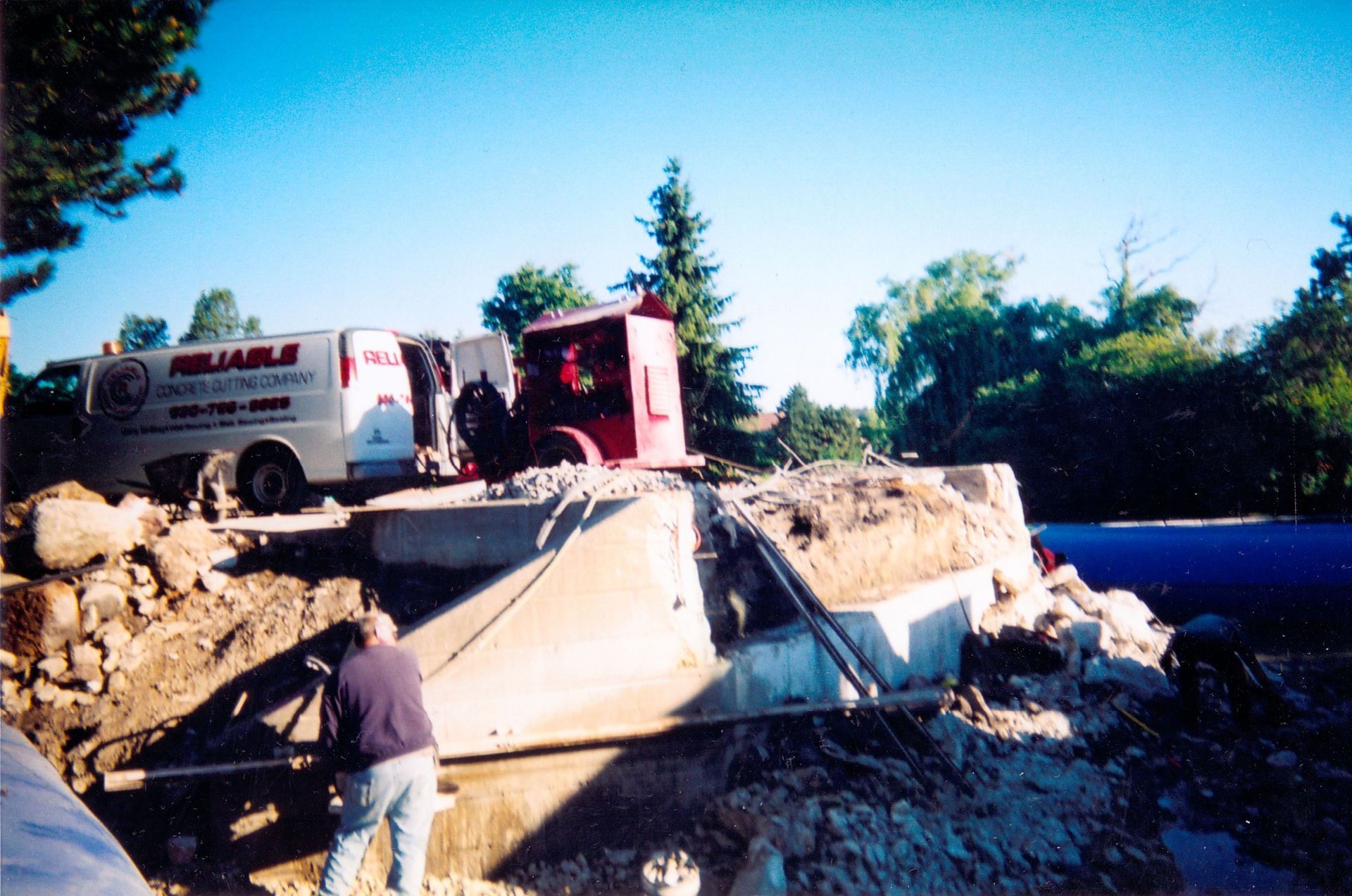 A man stands in front of a truck that says reliable