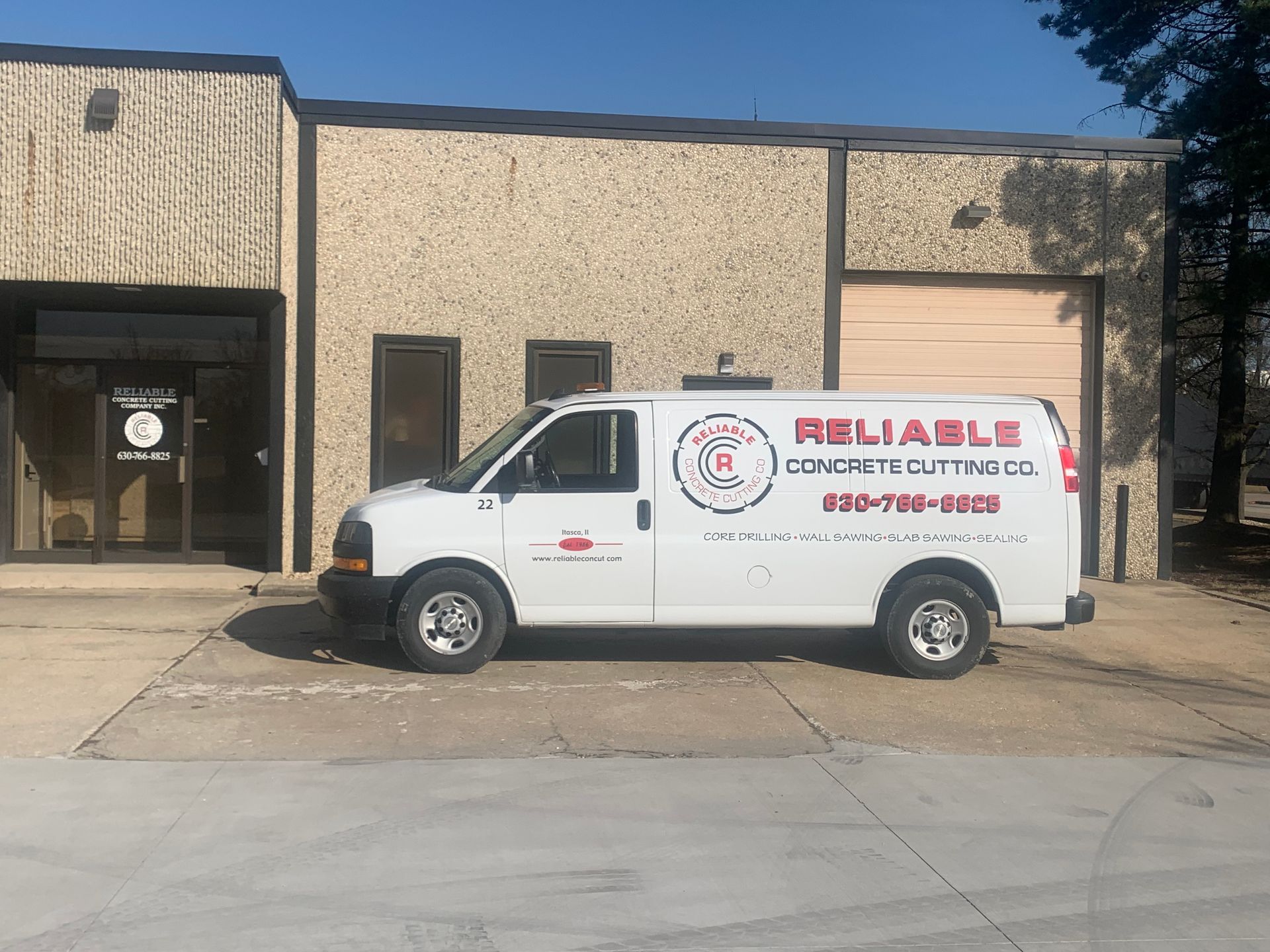 A white van is parked in front of a building.