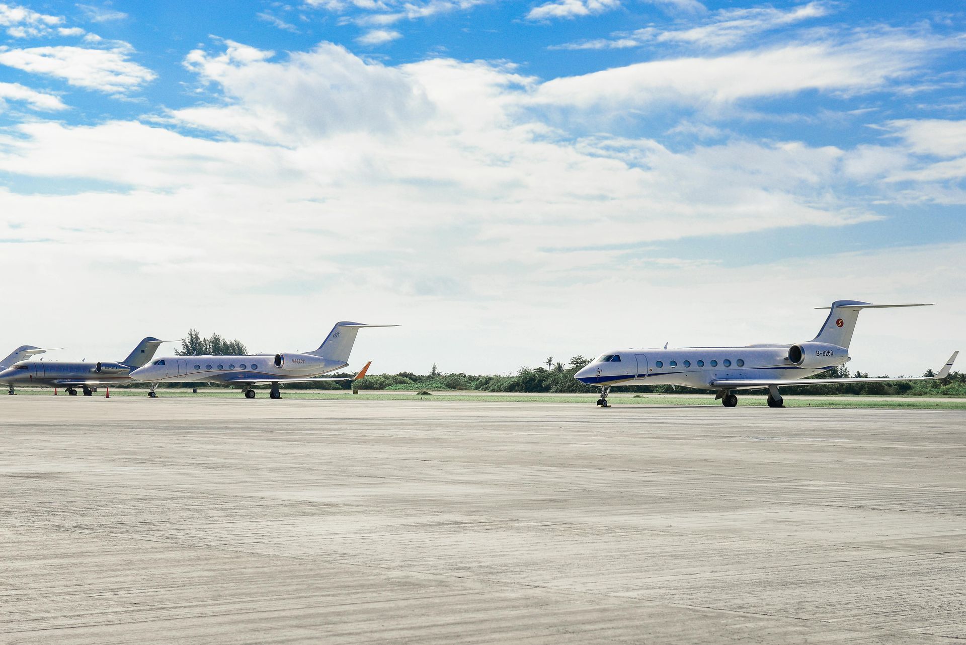 Two private jets are parked on a runway.