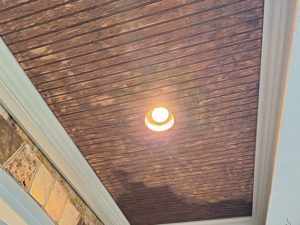 Brown textured ceiling with recessed light, framed by white trim.