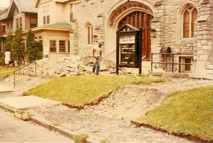 A man is standing in front of a Church