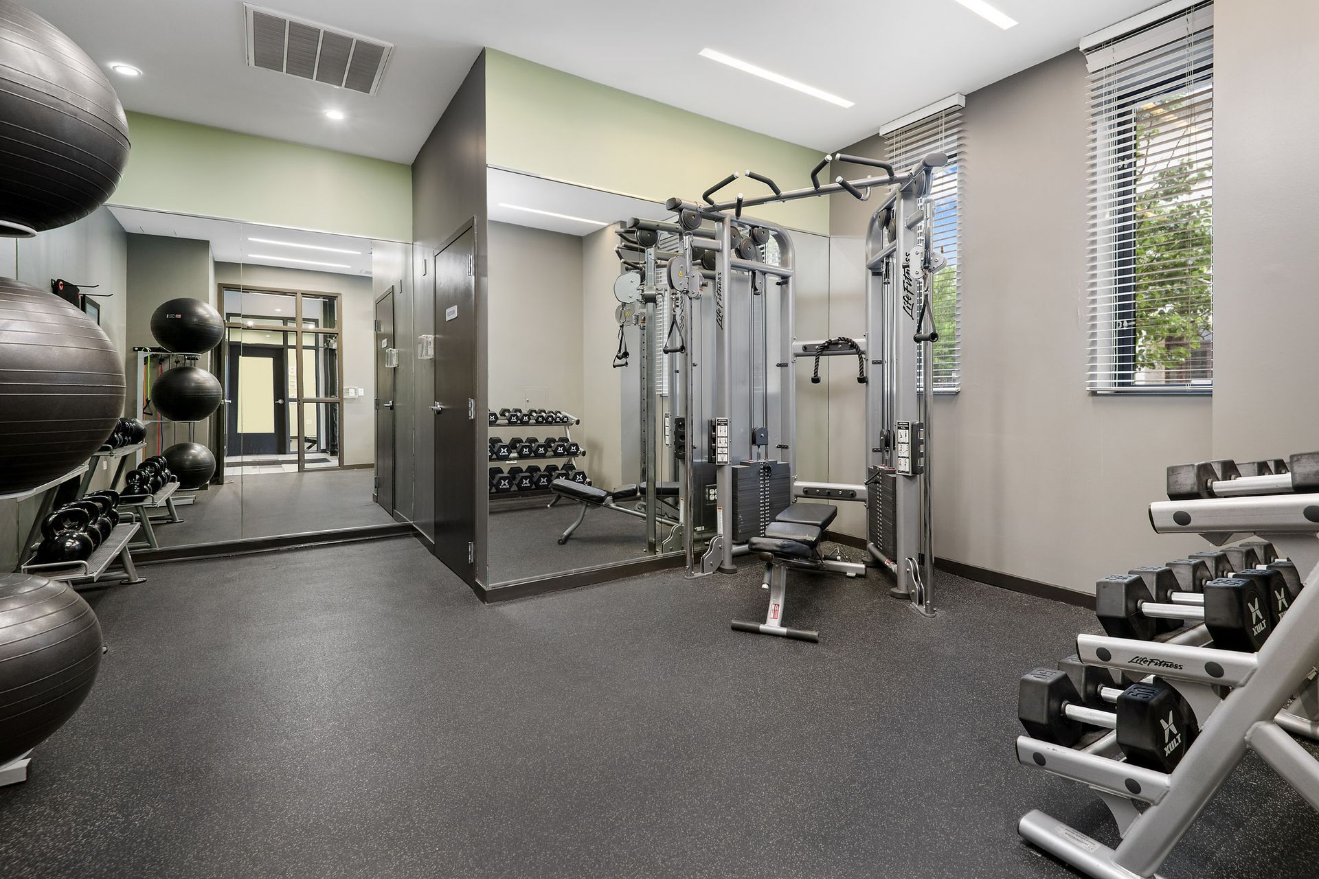 A gym with a lot of equipment and a large mirror at Reside on Clarendon.
