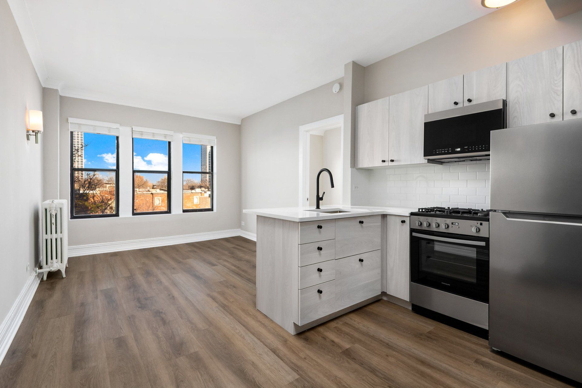 A kitchen with stainless steel appliances and a large window at Reside on Clarendon.