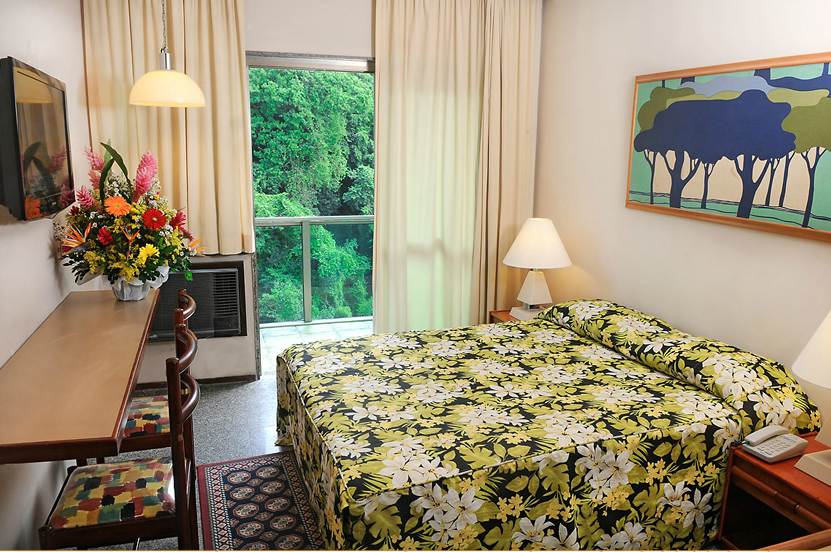 Um quarto de hotel com uma cama grande e uma pintura na parede