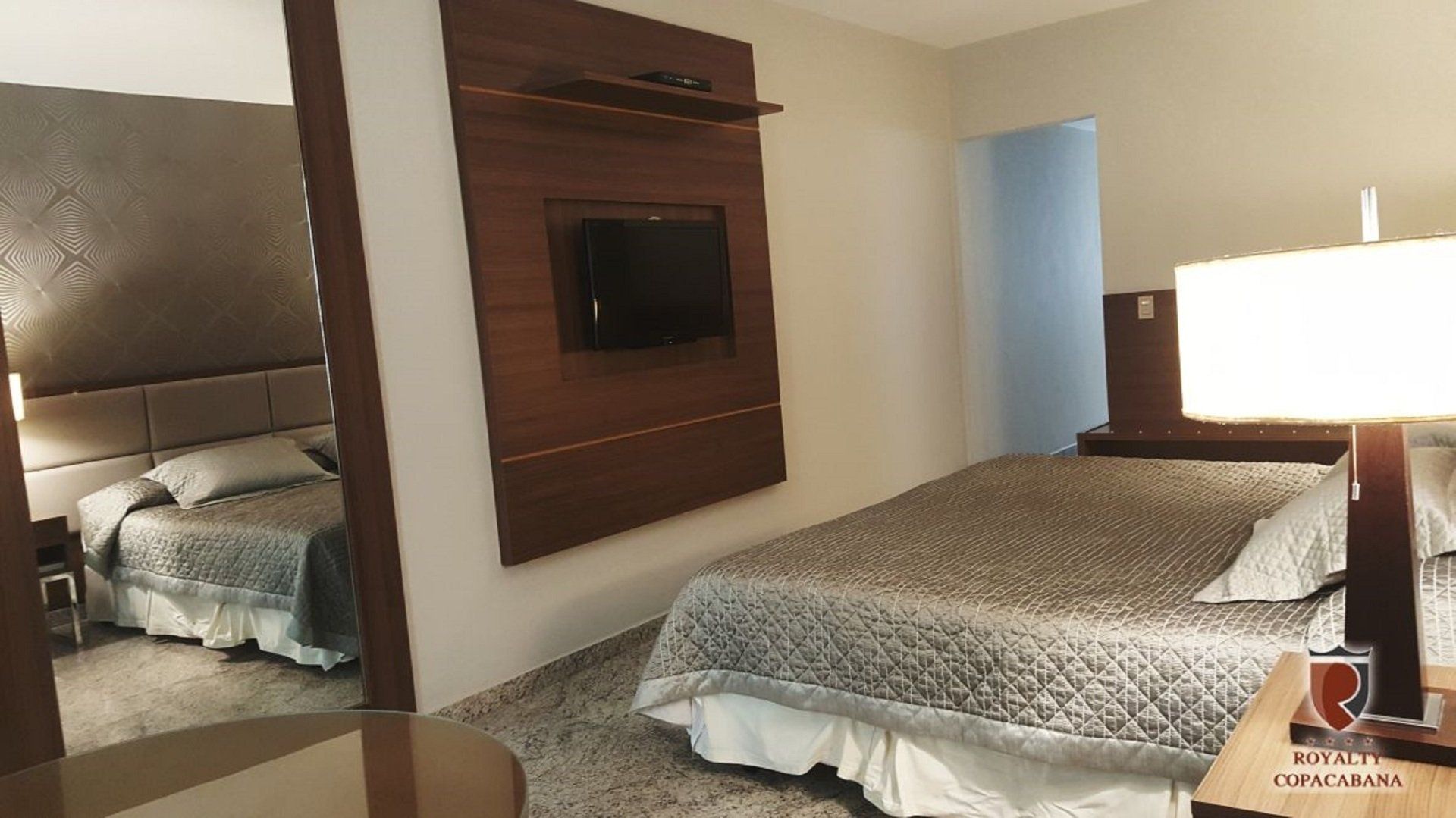 Um quarto de hotel com duas camas e uma TV de tela plana