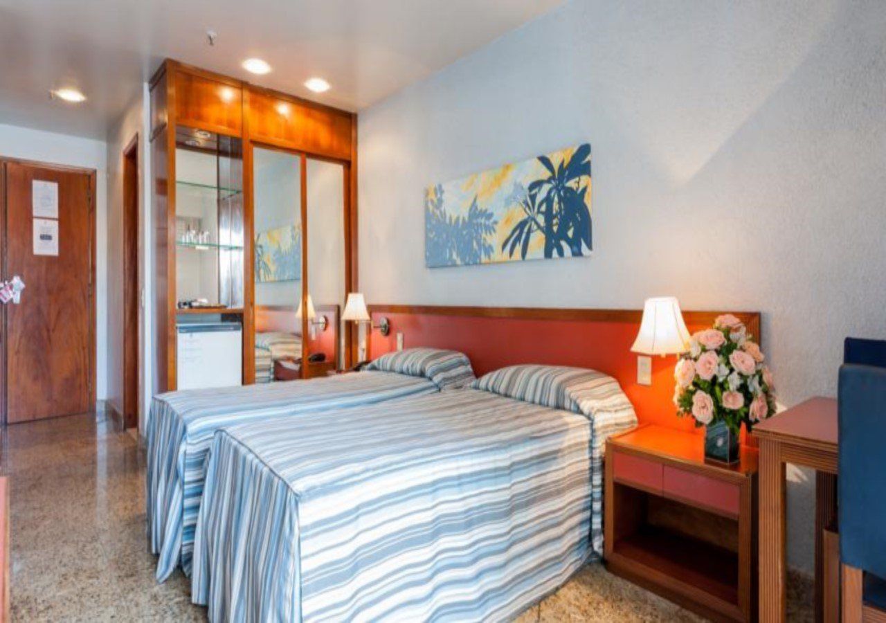 Um quarto de hotel com duas camas e uma escrivaninha