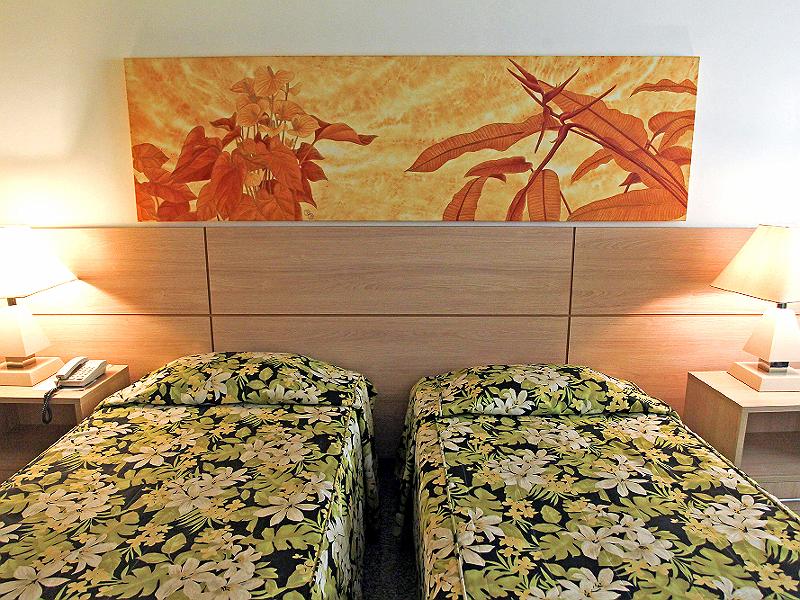 Um quarto de hotel com duas camas e uma pintura na parede