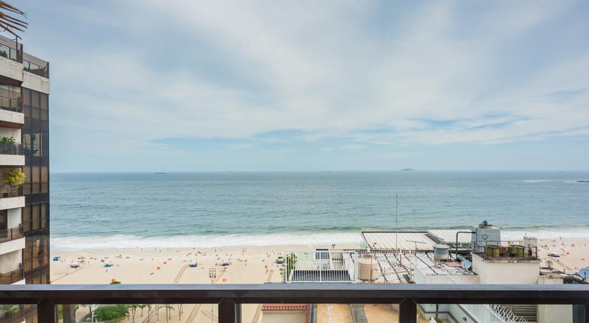 Uma varanda com vista para o oceano e para a praia.