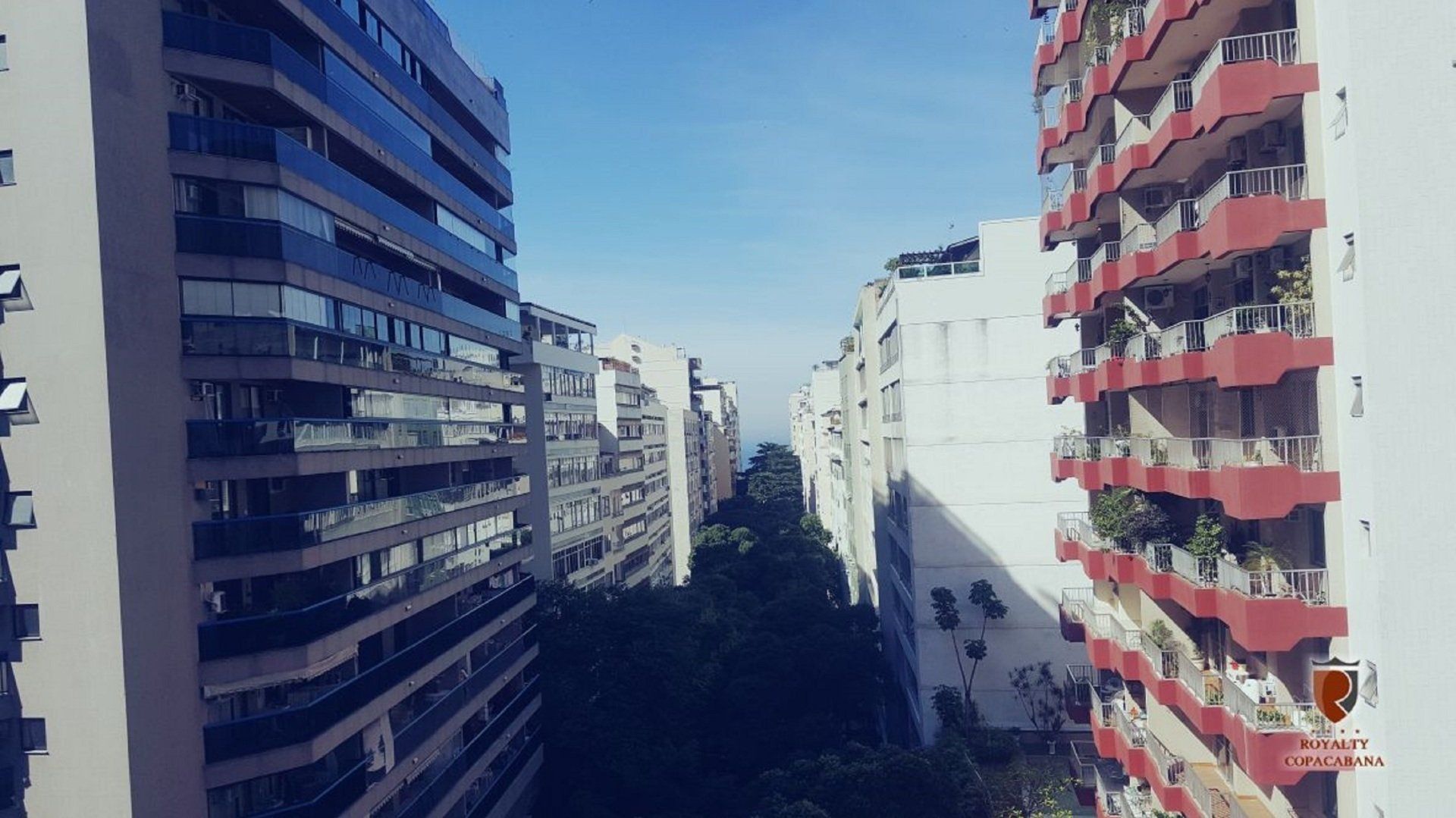 Uma fileira de edifícios altos com varandas vermelhas em uma cidade