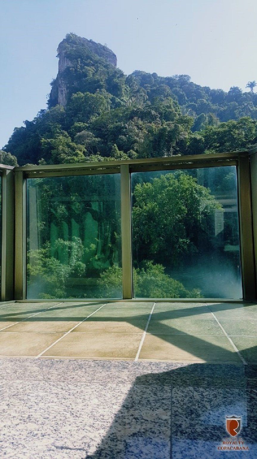 Uma grande janela com vista para uma montanha e árvores.