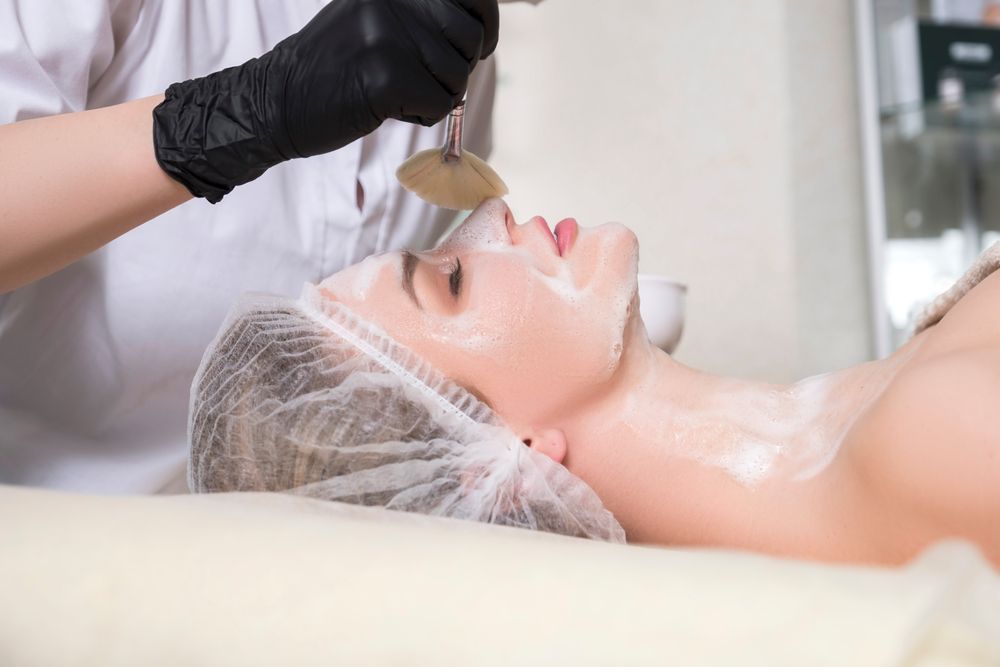 A Woman is Getting a Facial Treatment at a Beauty Salon — Kàllos Aesthetics by Nurse Kellie In Urangan, QLD