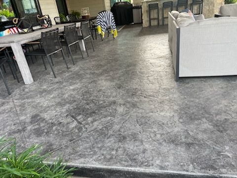 A patio with a couch , table and chairs on it.