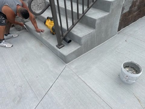 A man is working on a set of concrete stairs.