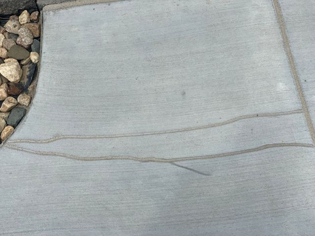 A close up of a concrete surface with rocks in the background