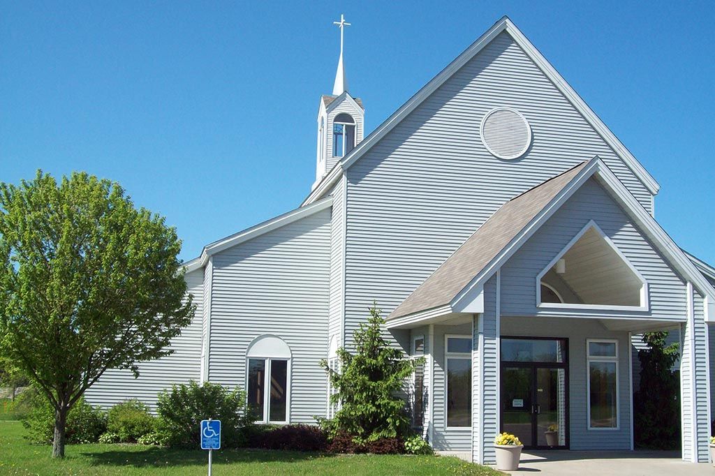 A white church with a cross on top of it