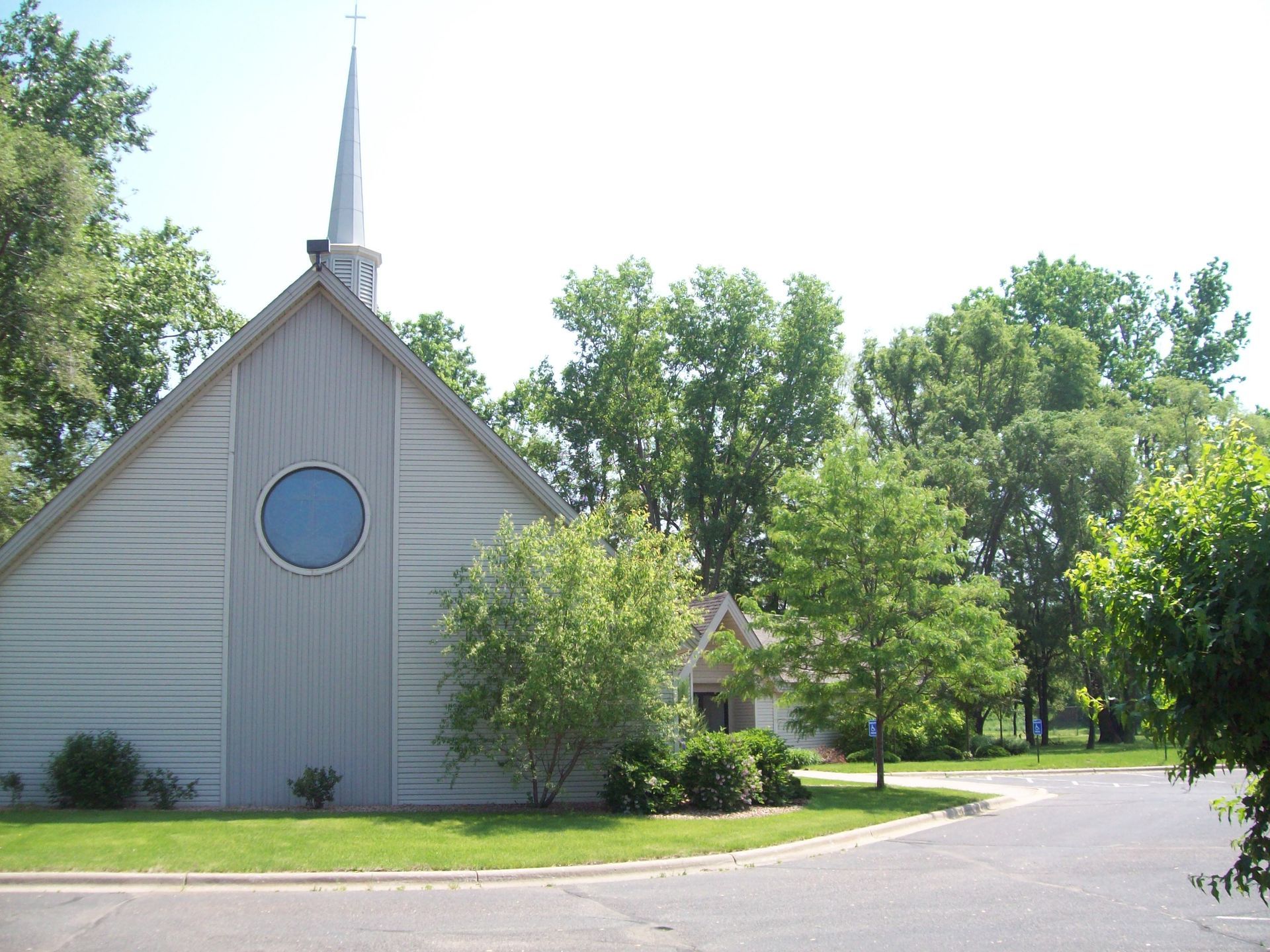 A church with a steeple and a blue window