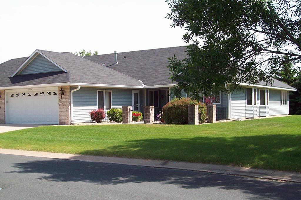 A house with a gray roof and a white garage door
