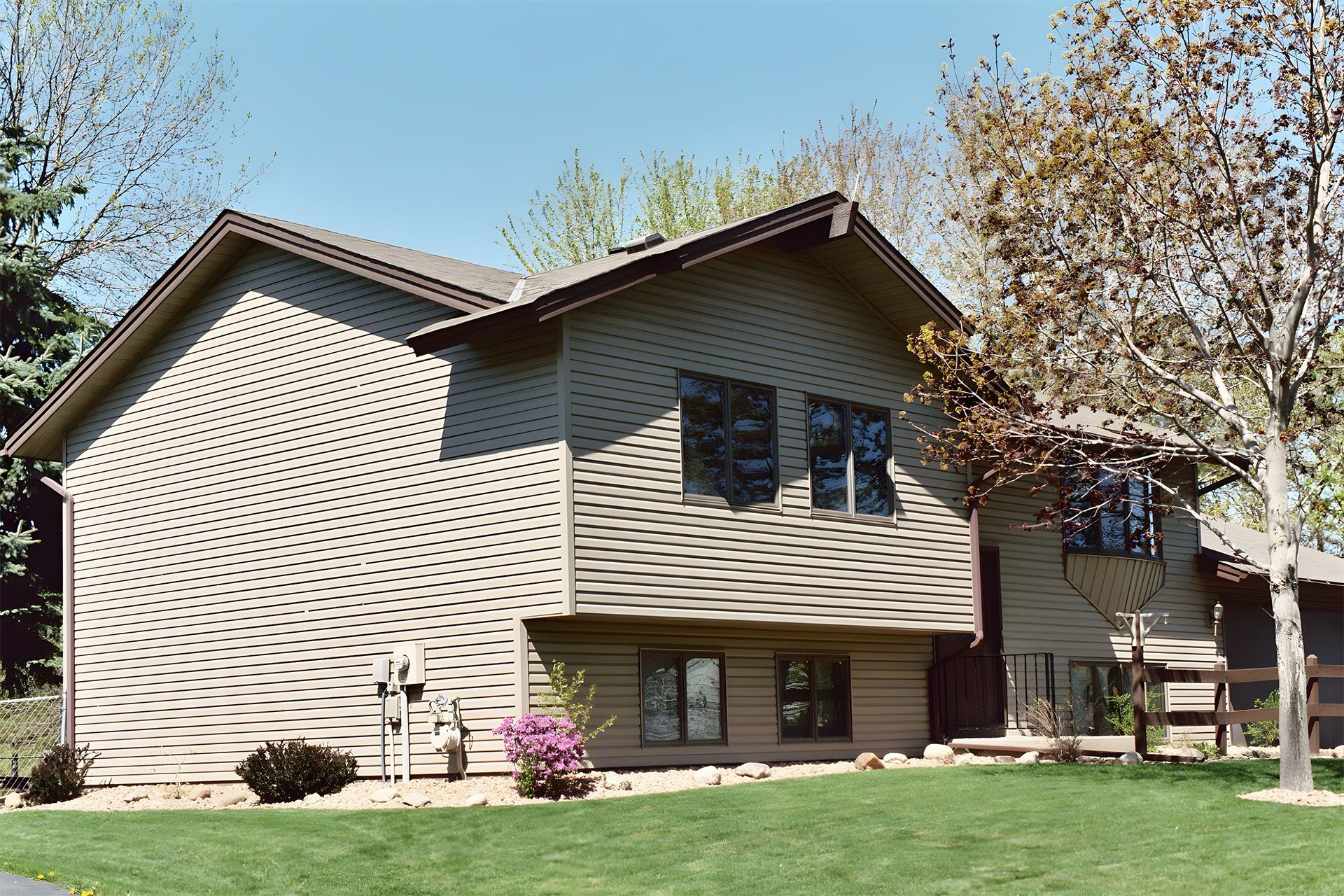 A house with a lot of windows and a lawn in front of it