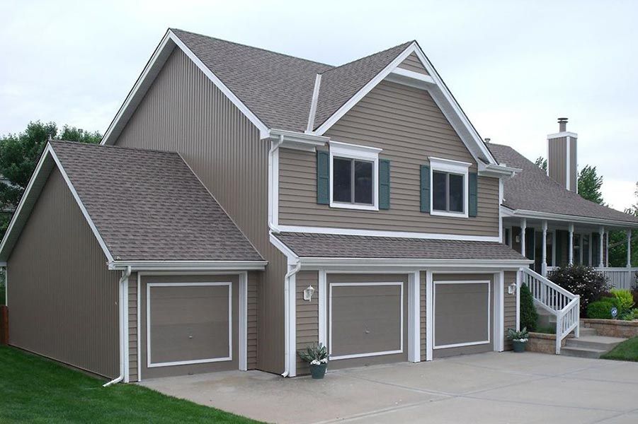 A large house with three garage doors and a staircase