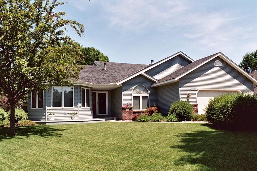 A house with a large lawn in front of it