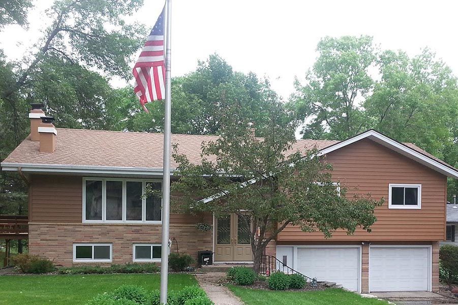 An american flag is flying in front of a house