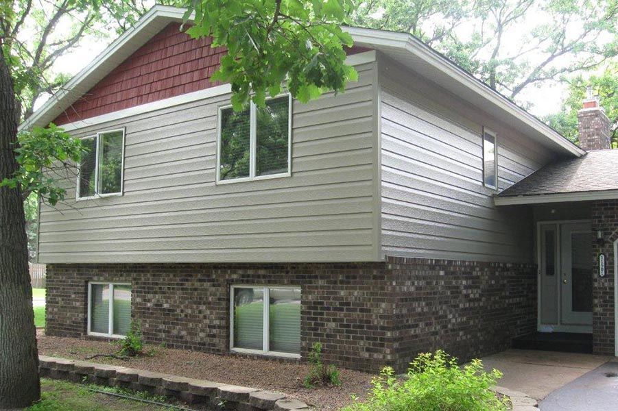 A house with a lot of windows and a tree in front of it.