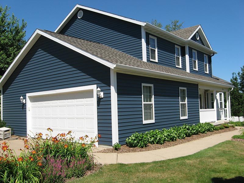 A large blue house with a white garage door