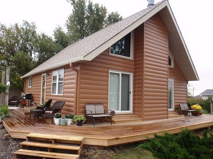 A small house with a wooden deck and stairs