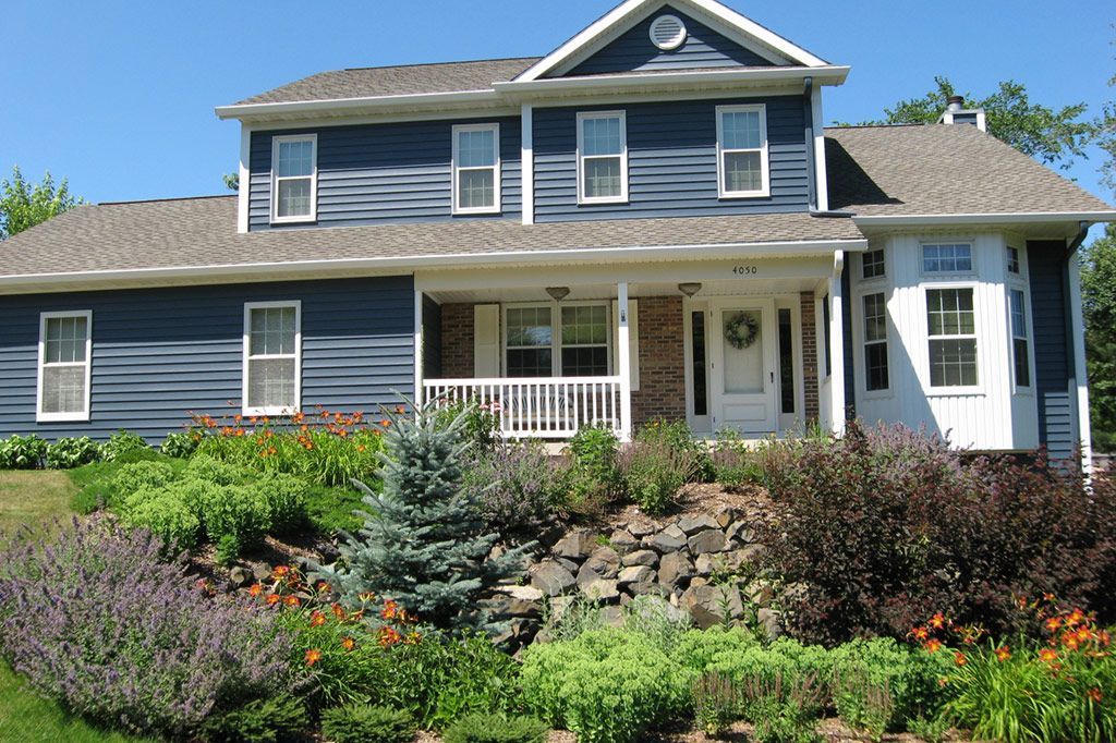 A large house with a large porch and lots of windows