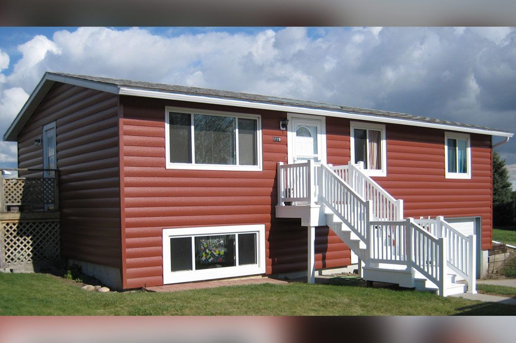 A red house with stairs leading up to the second floor