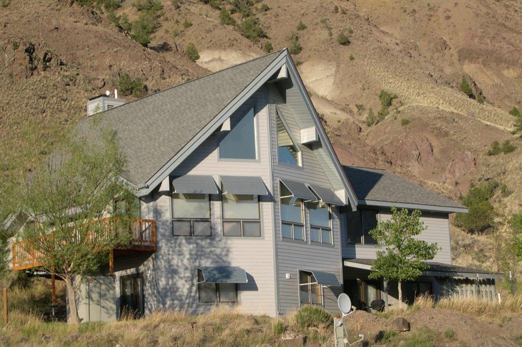 A large house sits on top of a hill in the desert