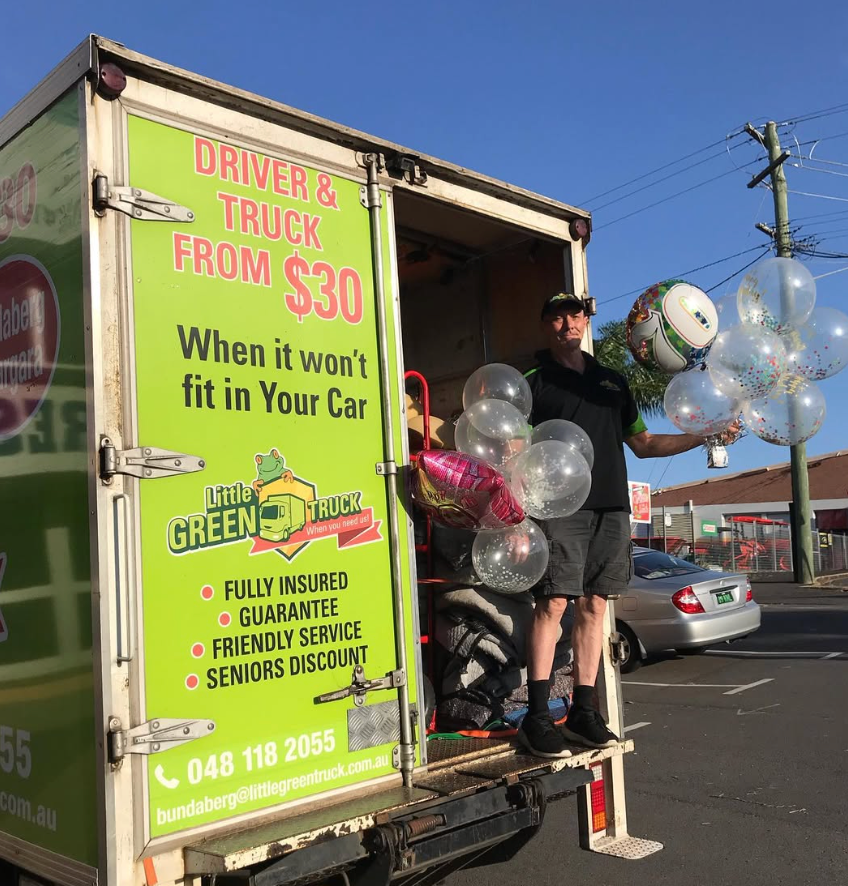 Man Pushing a Dolly With Easter Egg Cutouts Near a Moving Truck — Little Green Truck Bundaberg In Bundaberg, QLD